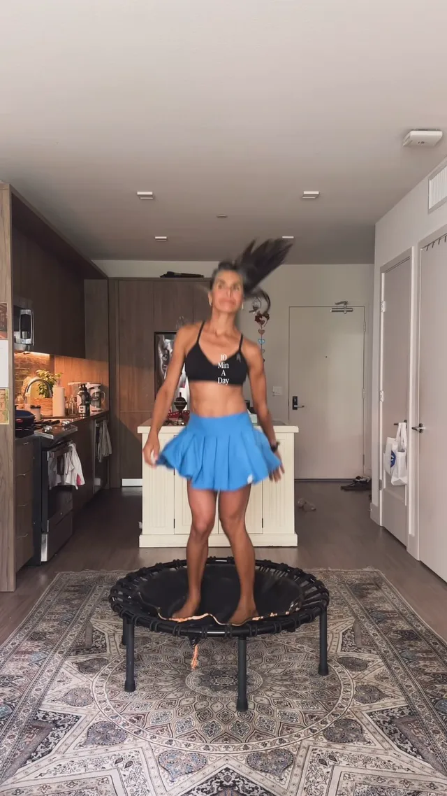 Maya exercising on a mini trampoline in her kitchen